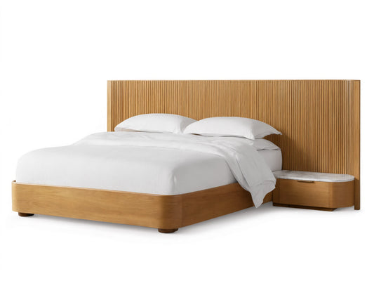 Finnley Extended Headboard Bed in Honey finish with vertical reeded wood headboard, integrated nightstand with stone top, and white bedding.