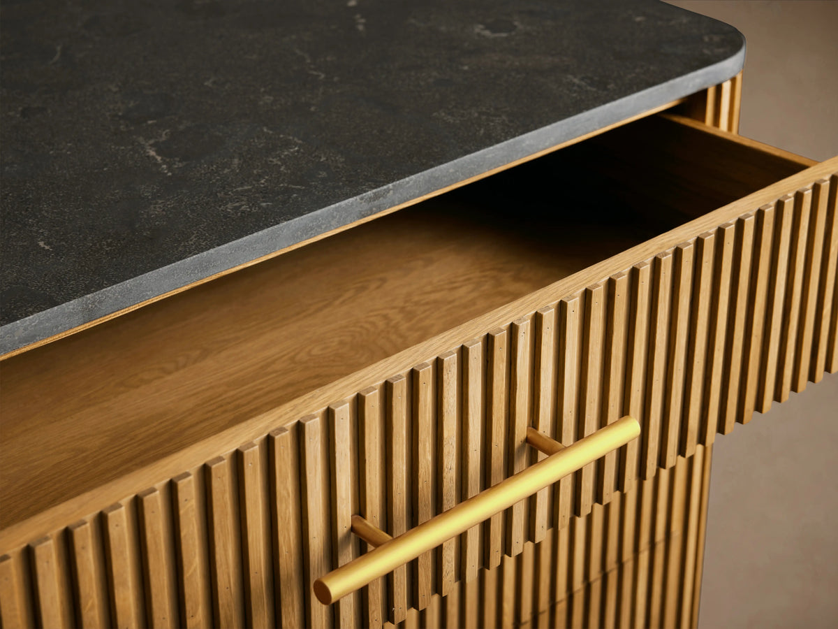 Finnley Five-Drawer Dresser, honey wood with vertical reeding, black stone top, gold-tone handles & legs. Two drawers open.