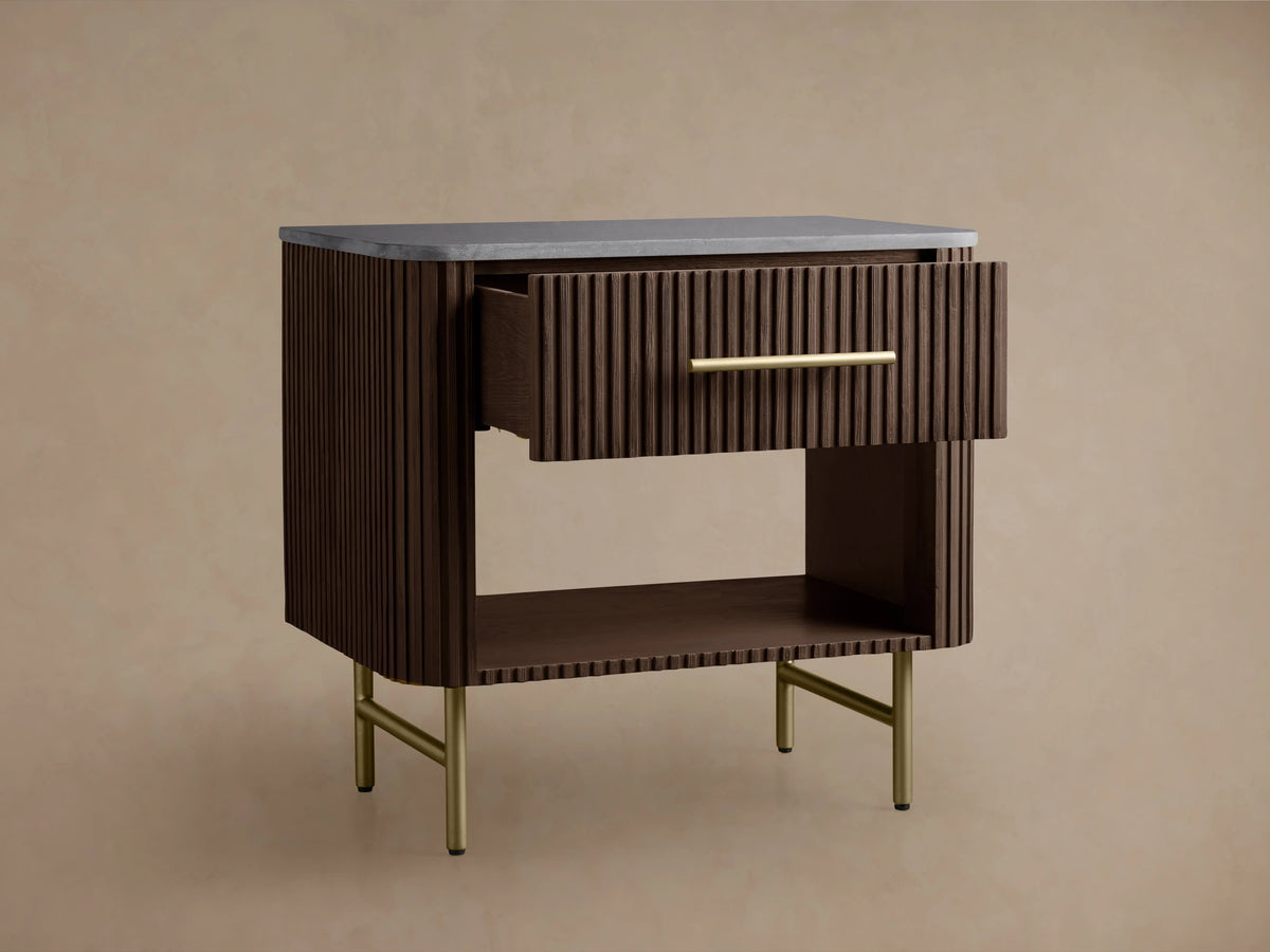 Finnley Open Nightstand with dark wood finish, vertical grooves, brass handle, black marble top, and four brass legs.