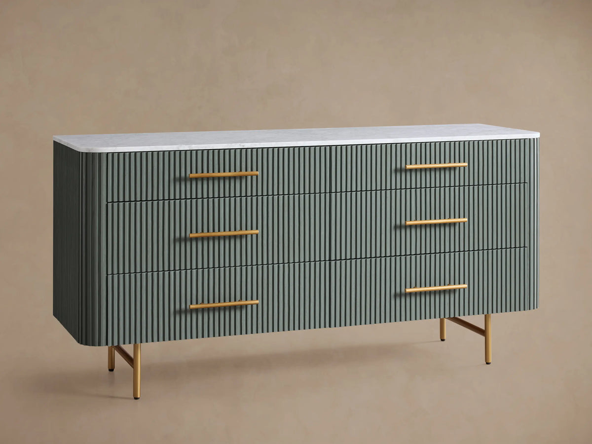 Finnley Six-Drawer Dresser: Sage green dresser with reeded drawers, white stone top, and brass hardware, on wood floor.