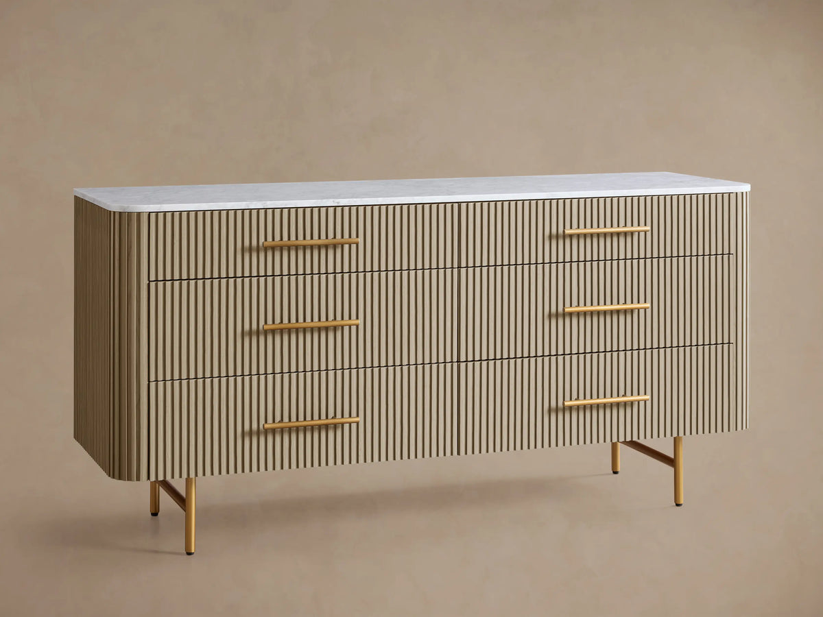 Finnley Six-Drawer Dresser. Light honey reeded wood dresser with white marble top, six brass-handled drawers, and brass legs.