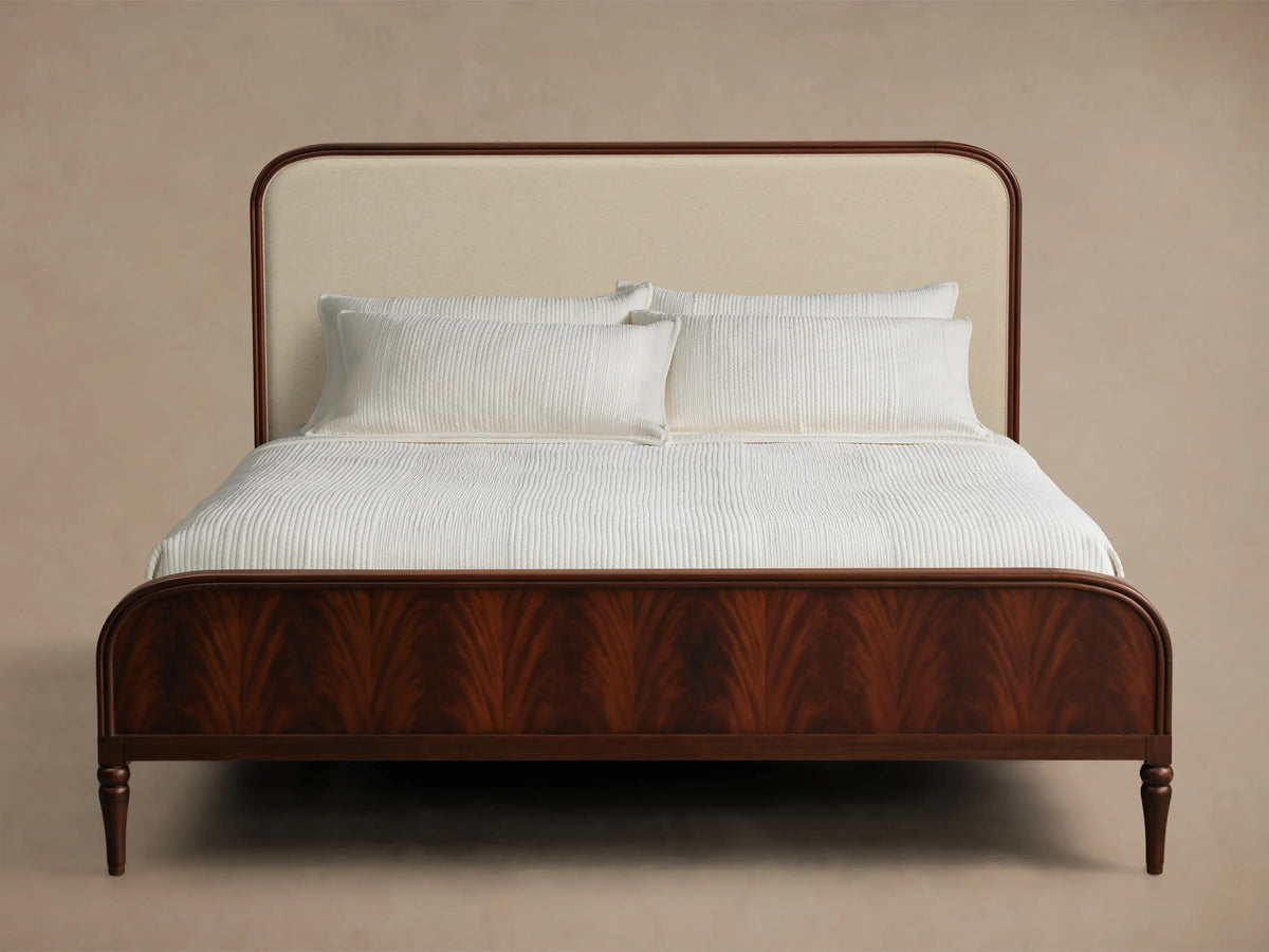 Front view of the Frances Bed featuring a dark mahogany frame with figured veneer and a cream upholstered headboard.