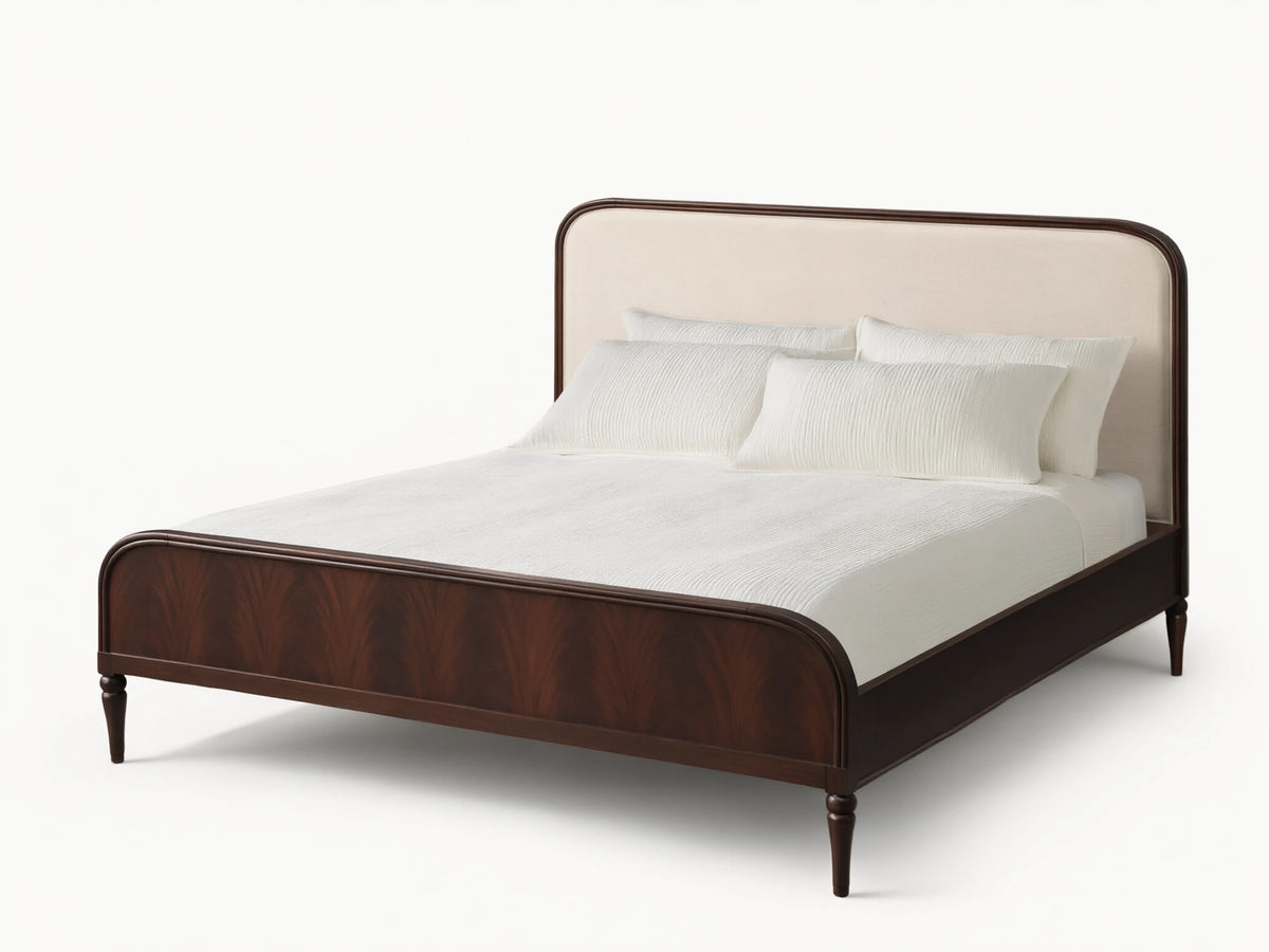 Front view of the Frances Bed, featuring a dark mahogany frame with figured veneer, curved cream upholstered headboard, and white bedding.