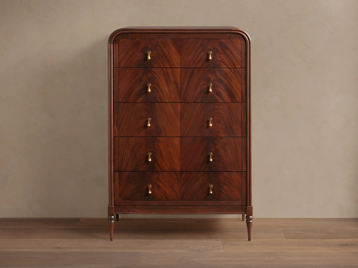 Frances Five-Drawer Dresser: Dark mahogany wood, rounded top, 5 stacked drawers, 10 brass pulls, on wooden floor.