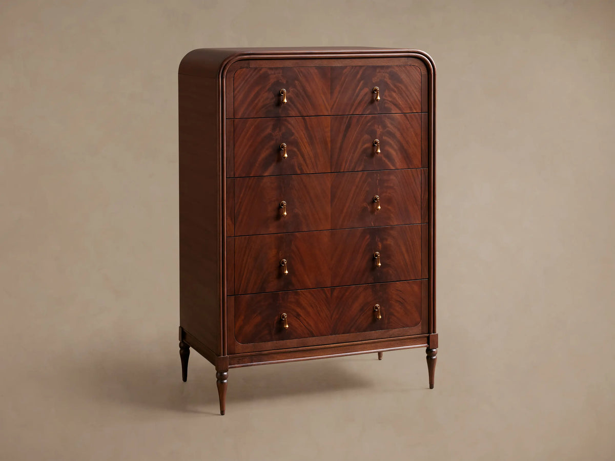 Frances Five-Drawer Dresser: Dark mahogany wood, rounded top, 5 stacked drawers, 10 brass pulls, on wooden floor.