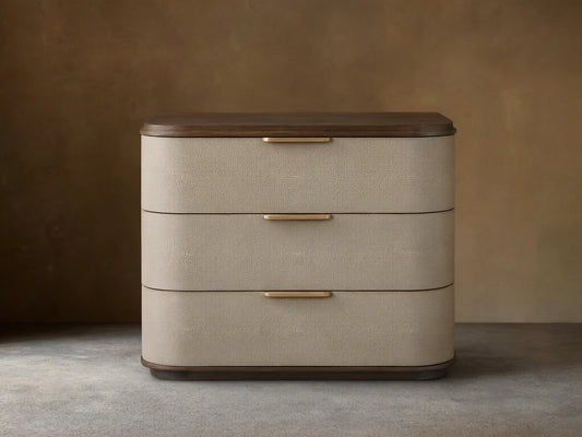 Harrow Nightstand with 3 light beige faux shagreen drawers, dark wood top/base, and champagne-brass bar pulls, front view.