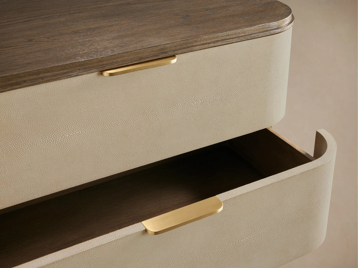 Harrow Five-Drawer Dresser, light beige faux shagreen with rounded edges, dark wood top/base, and five brass bar handles.