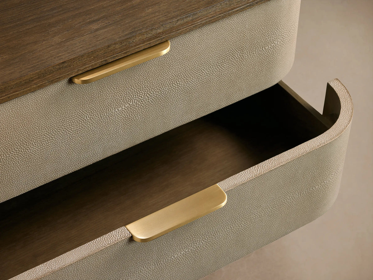 Full-view of Harrow Six-Drawer Dresser with rounded edges, light beige faux shagreen drawers, dark wood top & brass pulls.