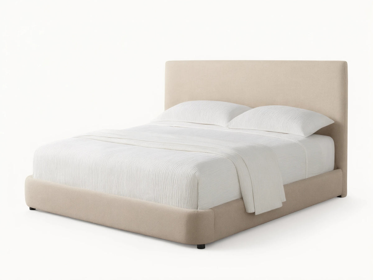 Front view of the beige upholstered Hathaway Bed, showing its curved headboard and platform, with off-white ribbed bedding.
