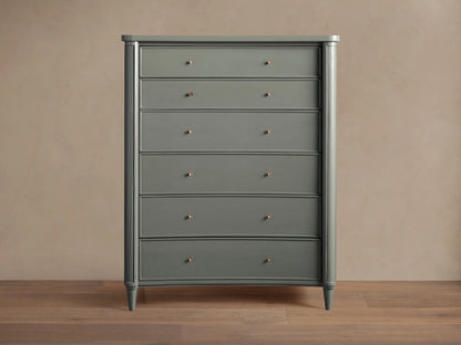 Henley Six-Drawer Dresser in gray finish, with petite brass pulls on each drawer, standing against a beige wall on wooden flooring.
