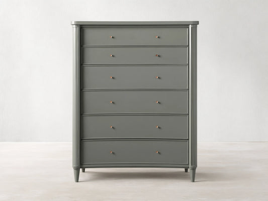 Henley Six-Drawer Dresser in gray finish, with petite brass pulls on each drawer, standing against a beige wall on wooden flooring.