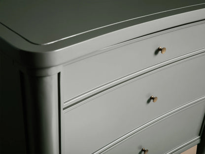 Henley Nightstand with a smooth, curved design in gray finish, featuring three drawers with petite brass pulls; elegant wood texture.