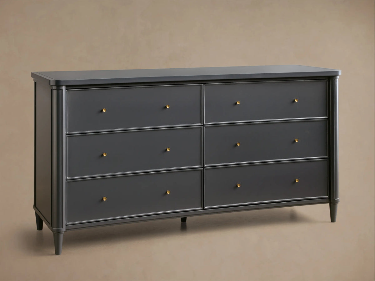 Front view of the black Henley Wide Six-Drawer Dresser, with six drawers featuring petite brass pulls. A lamp and vase are on top.