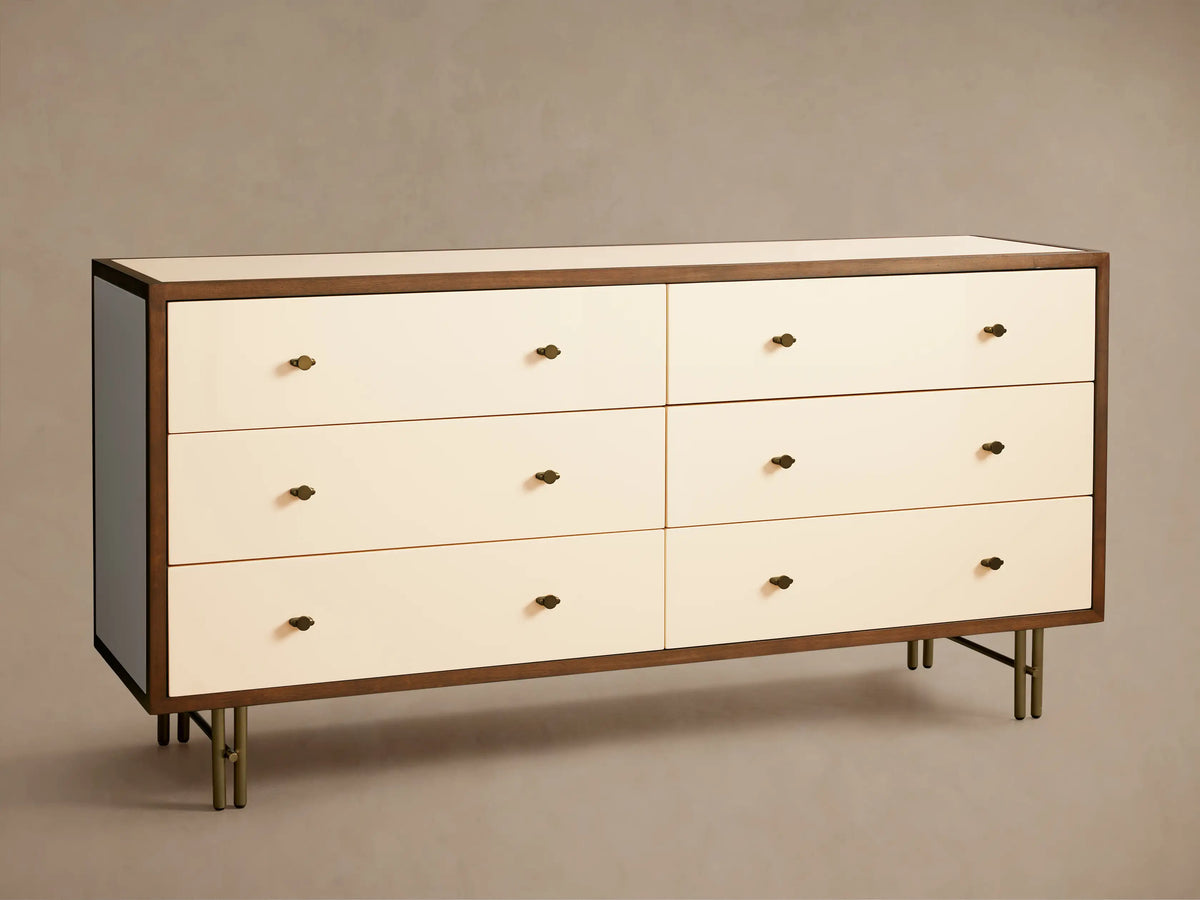 Henton Six-Drawer Dresser with cream drawers, dark wood frame, brass knobs, and brass-finished tubular legs.