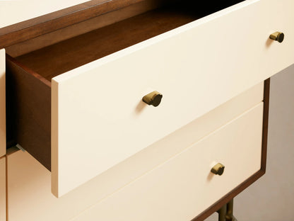 Henton Six-Drawer Dresser with six cream drawers, dark brown frame, brass knobs, and thin gold metal legs, slightly angled view.