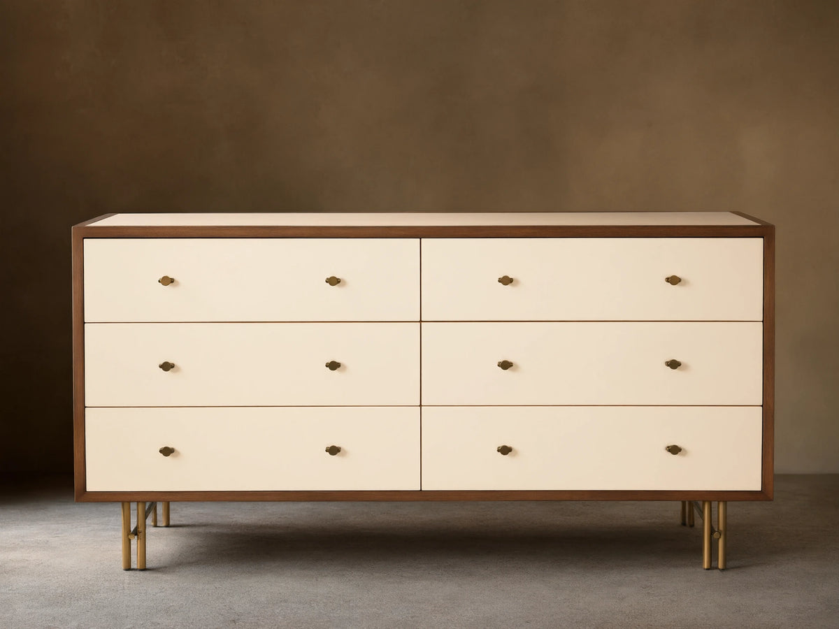 Henton Six-Drawer Dresser with cream drawers, dark wood frame, brass knobs, and brass-finished tubular legs.