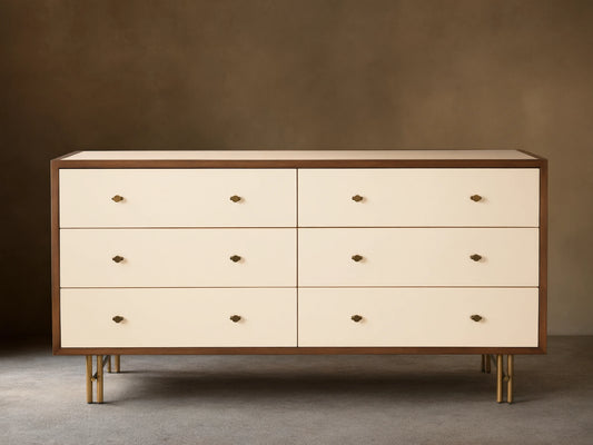 Henton Six-Drawer Dresser with cream drawers, dark wood frame, brass knobs, and brass-finished tubular legs.
