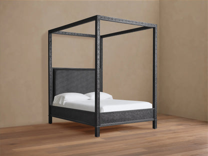 Keene Canopy Bed: Dark brown wooden frame with intricate patterns, brown leather headboard, and white bedding on wood floor.