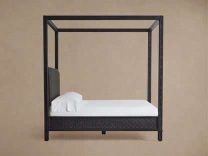 Keene Canopy Bed close-up: intricately carved dark mango wood frame next to a dark brown leather padded headboard.