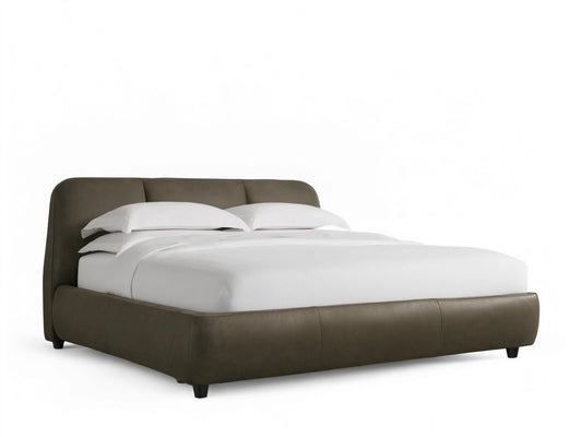 Front view of the dark brown Kinnan Leather Bed with a rounded, three-paneled headboard, upholstered frame, and white bedding.