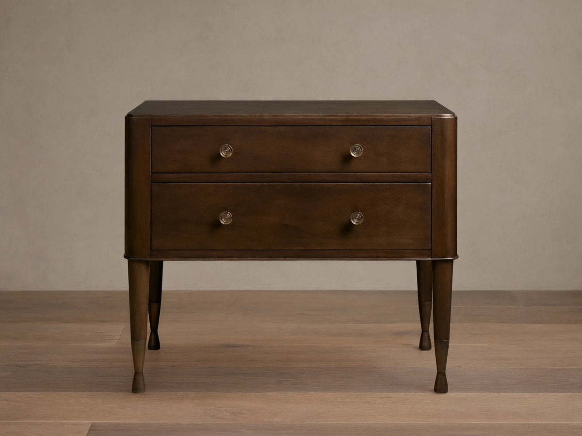 Laurent Nightstand with dark wood finish, featuring two drawers with brass knobs and elegant tapered legs on a wooden floor.