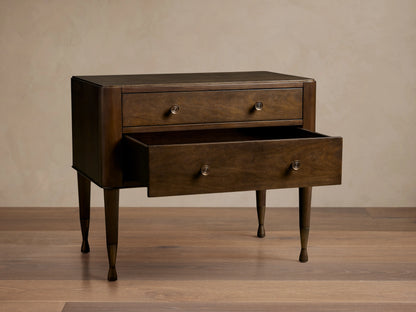 Laurent Nightstand with two visible drawers, one open, crafted in dark mahogany wood, accented with patinaed brass feet, on wood floor.