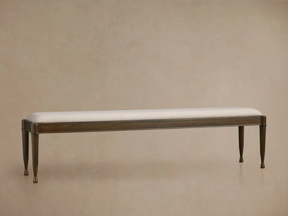 Laurent Bench with a sleek rectangular silhouette, solid wood frame, light upholstered seat, and patinaed brass feet.