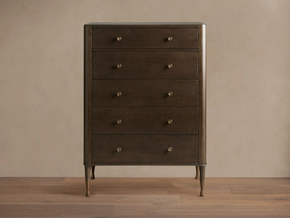 Laurent Five-Drawer Dresser made of dark mahogany and cherry veneers, features patinaed brass feet and knobs, in a neutral setting.