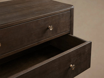 Laurent Five-Drawer Dresser made of dark mahogany and cherry veneers, features patinaed brass feet and knobs, in a neutral setting.