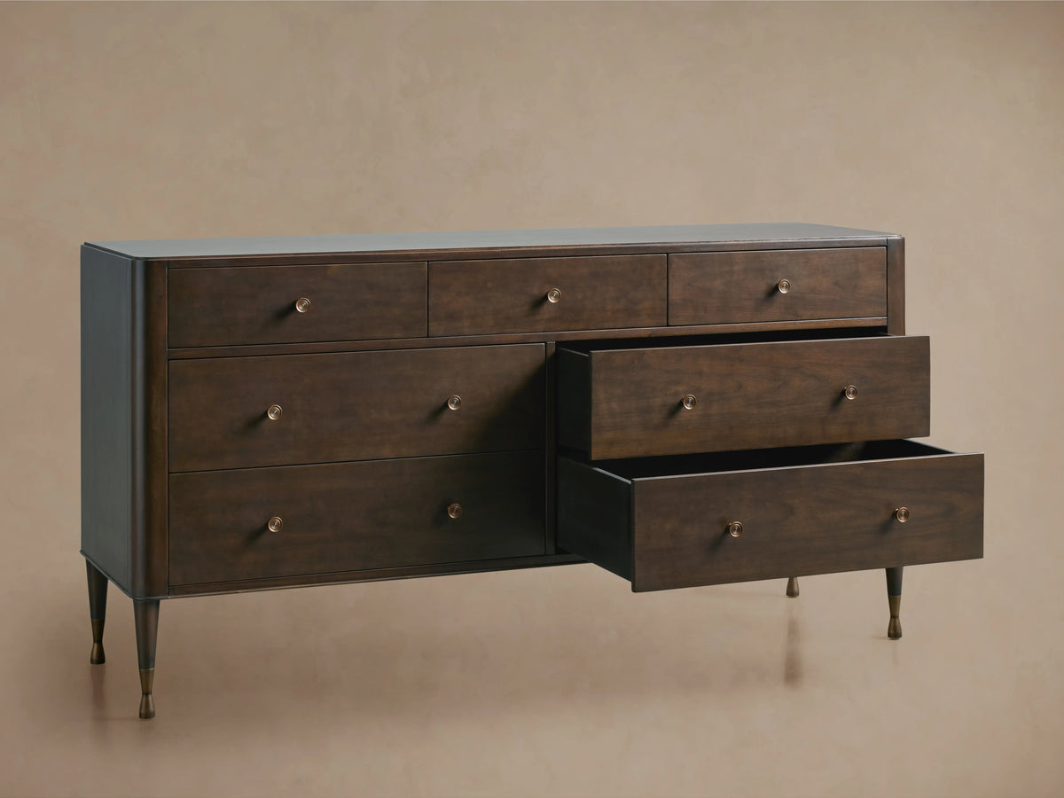 Laurent Seven-Drawer Dresser in dark wood finish, featuring three slightly open drawers, patinaed brass feet, and hardware.