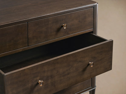 Laurent Seven-Drawer Dresser in dark wood, featuring seven drawers with patinaed brass knobs, stands on slender brass-accented legs.