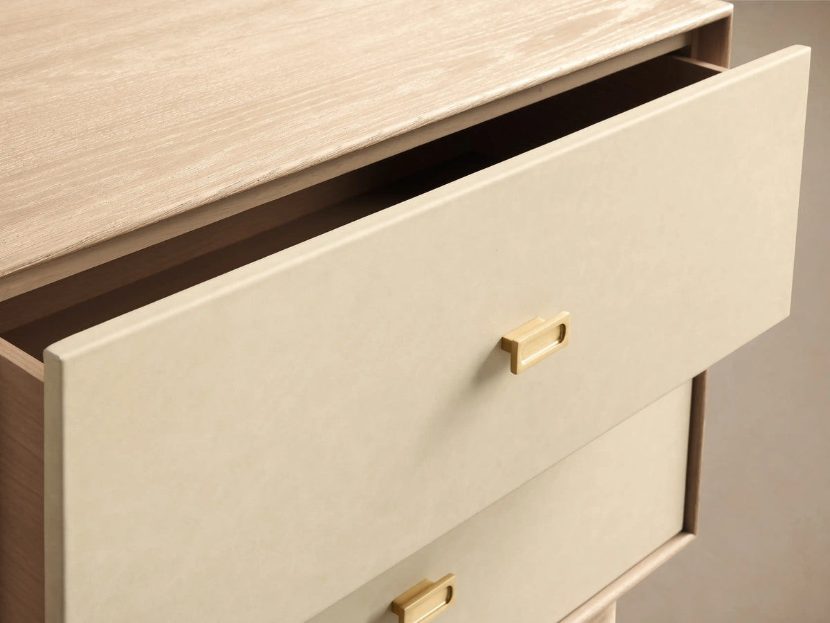 Front view of the Lowen Nightstand with light oak wood veneer frame and two cream faux leather drawers with champagne brass pulls.
