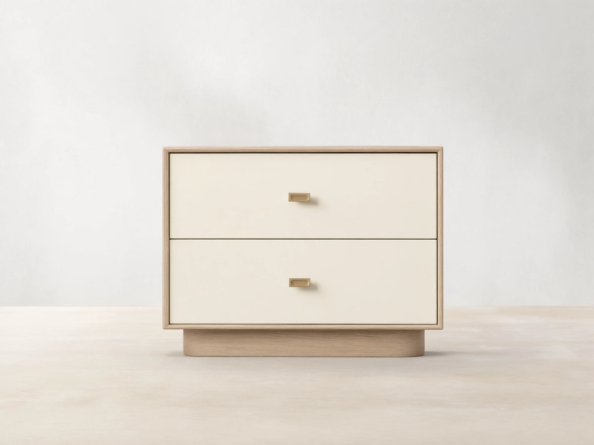 Front view of the Oak Lowen Nightstand, featuring two parchment faux leather drawers with champagne brass pulls.