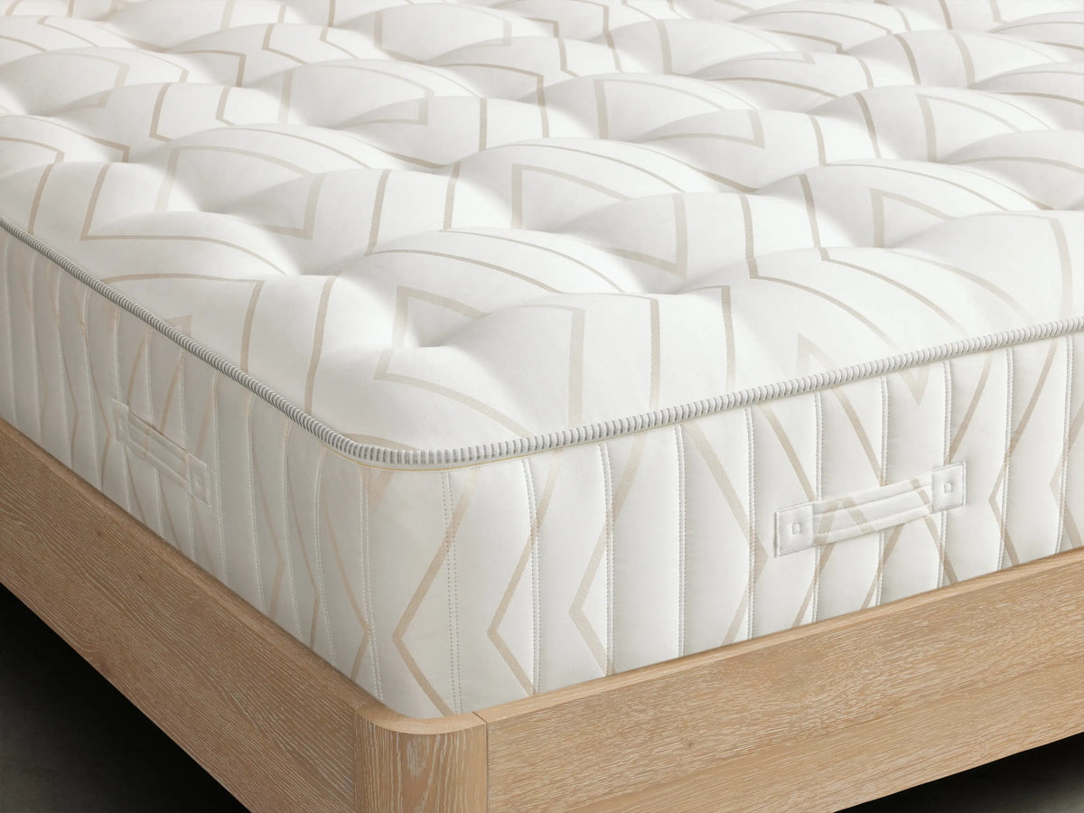 Luxury Firm Mattress surface with beige stripes and visible tufting in the center on the white fabric.