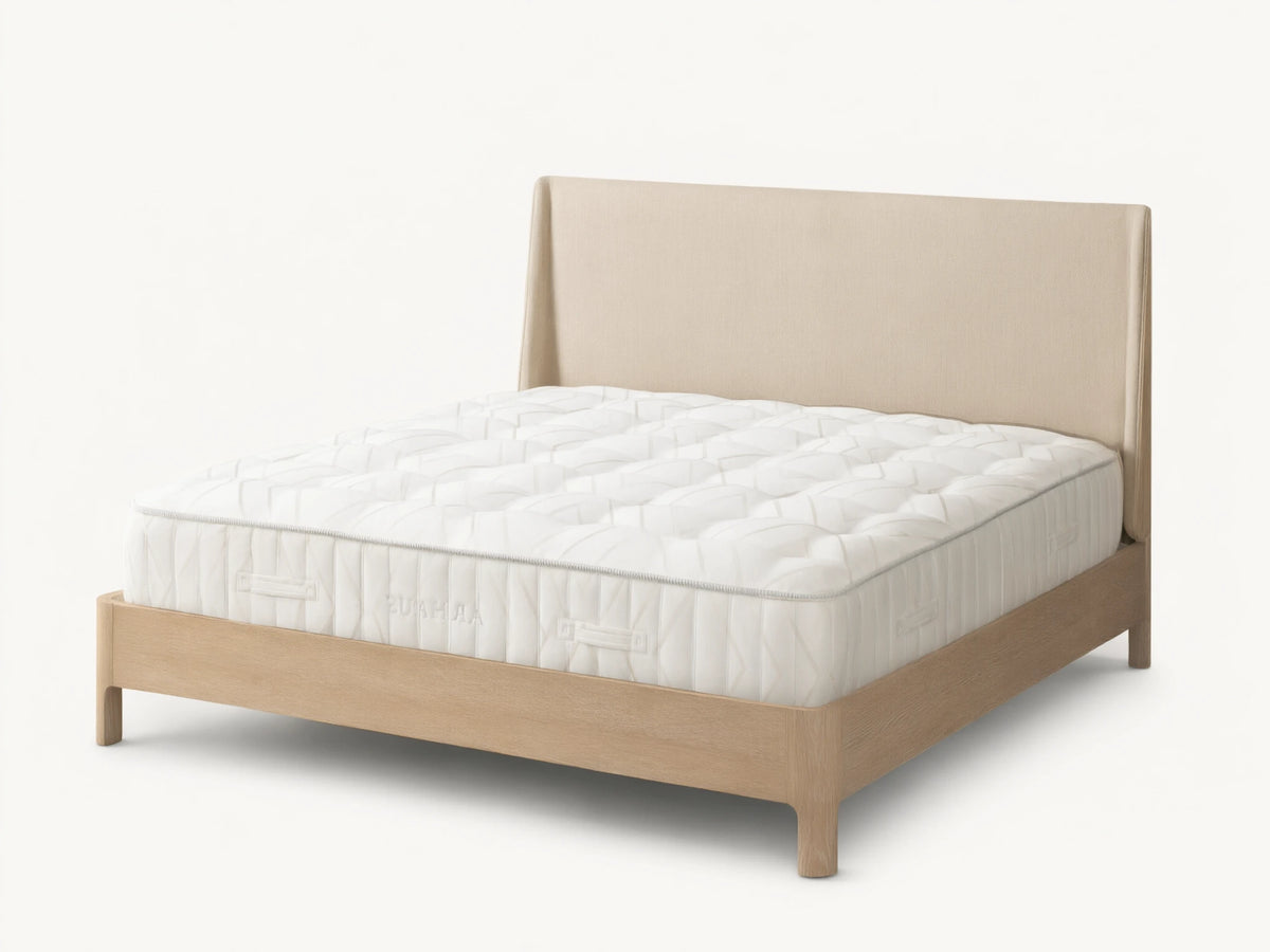 Luxury Firm Mattress on a wooden bed frame with a beige fabric headboard, featuring a quilted white surface and rectangular patterns.
