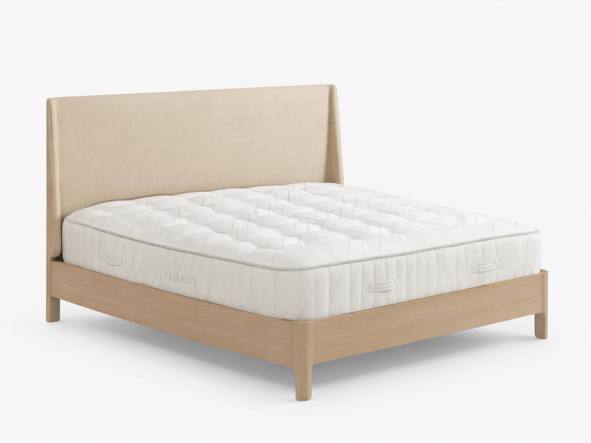 Alt text: Luxury Firm Mattress on a wooden bed frame with a beige upholstered headboard, featuring a white quilted surface and a 14-inch height.