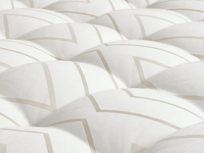 Luxury Plush Mattress on a light wood bed frame, featuring white quilted surface and embroidered handles, with a neatly placed throw blanket.