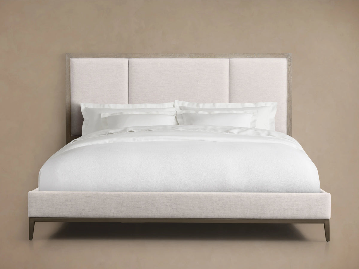 Malone Upholstered Bed in neutral tones, featuring a headboard with three channel-stitched panels, white bedding, and wood frame.