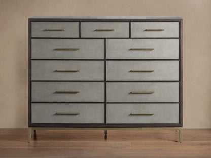 Malone Eleven-Drawer Dresser. Dark wood frame, light grey shagreen-textured drawers with gold handles, and brass base.
