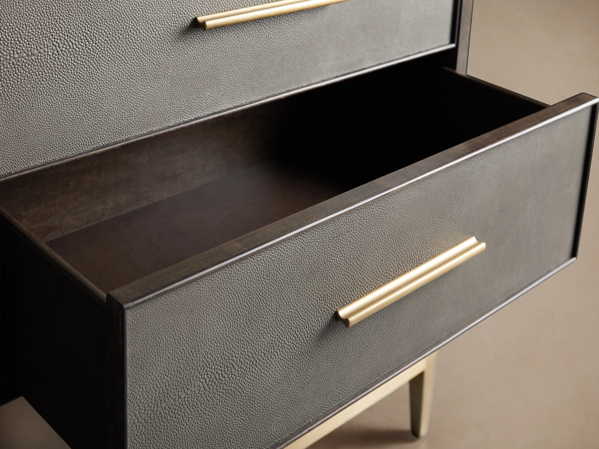 Dark wood Malone dresser, 11 gray shagreen leather drawers with brass bar pulls, on a gold metal base.