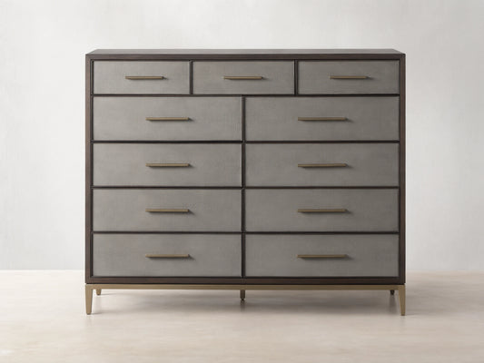Malone Eleven-Drawer Dresser. Dark wood frame, light grey shagreen-textured drawers with gold handles, and brass base.