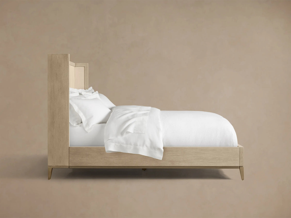 Close-up of the Malone Shelter Bed's light oak wood frame and bone-colored shagreen-embossed leather inset.