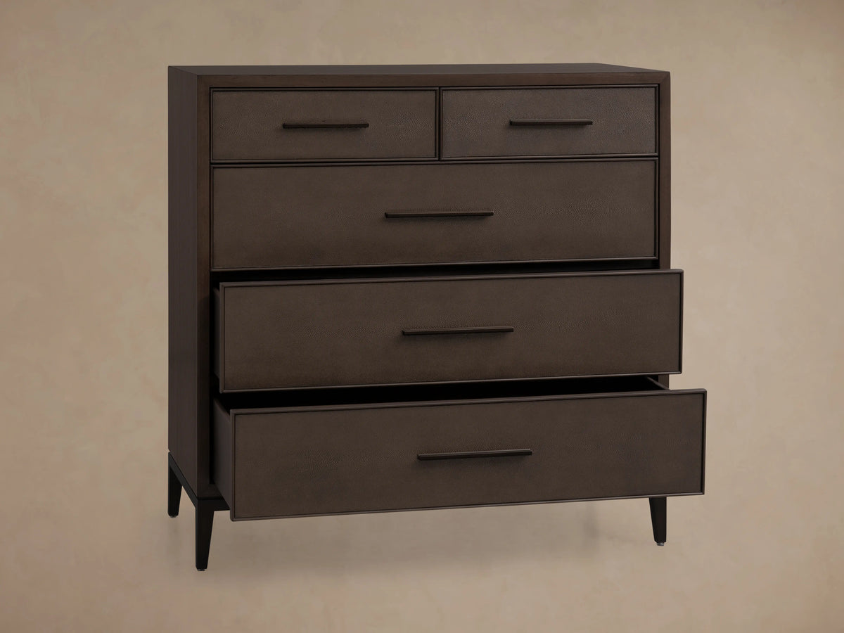Malone Five-Drawer Dresser in dark wood finish, one drawer partially open. Textured leather insets and metallic handles visible.