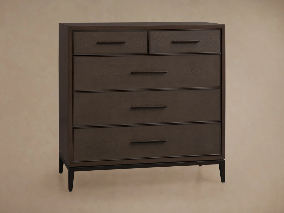 The Malone Five-Drawer Dresser features a dark wood finish with two top drawers and three larger drawers below. Two lower drawers are slightly open, revealing soft-close mechanisms.