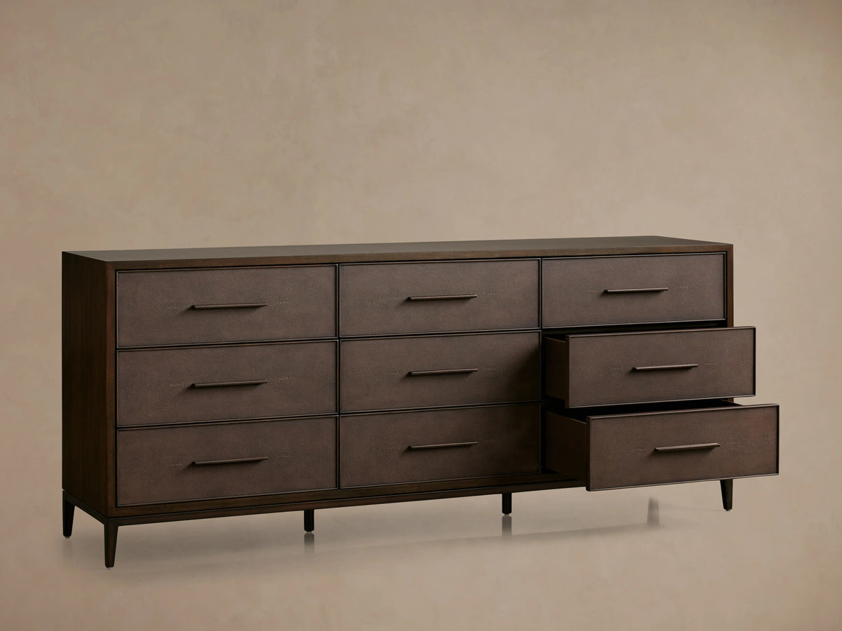 Malone Nine-Drawer Dresser in dark wood, featuring a drawer with textured leather insets and metallic handle, partially open.