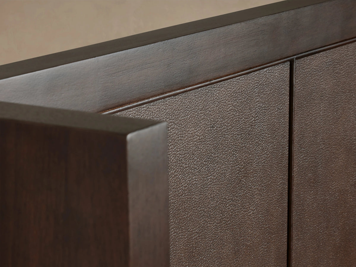 Close-up of Malone Shelter Bed headboard with dark wood frame and textured brown leather inset, highlighting craftsmanship and detail.