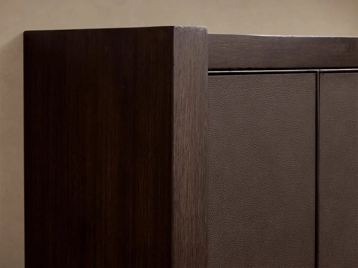 Malone Shelter Bed with a dark wood frame and high headboard in rich brown leather, white bedding, on a beige background.