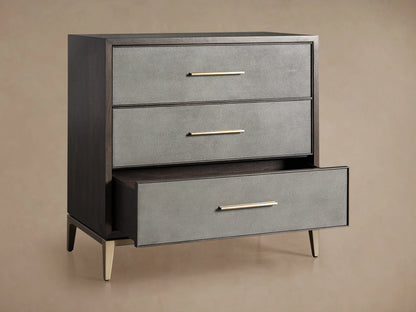 Malone Three-Drawer Chest detail showing a dark wood top and a textured reconstituted leather front with a sleek metallic handle.