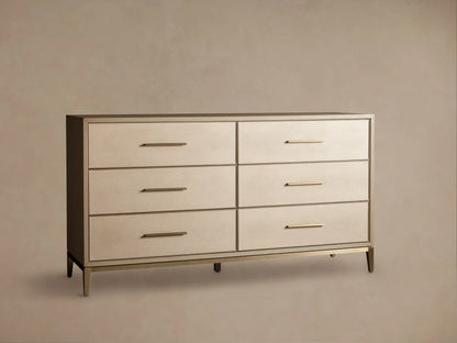 Front view of the Bone Malone Six-Drawer Dresser, featuring light beige textured shagreen drawer fronts, gold bar pulls, and tapered gold legs.