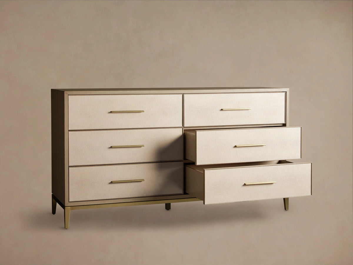 Front view of the Malone Six-Drawer Dresser with light beige shagreen leather drawer fronts, a dark brown frame, and warm gold metallic pulls and base.